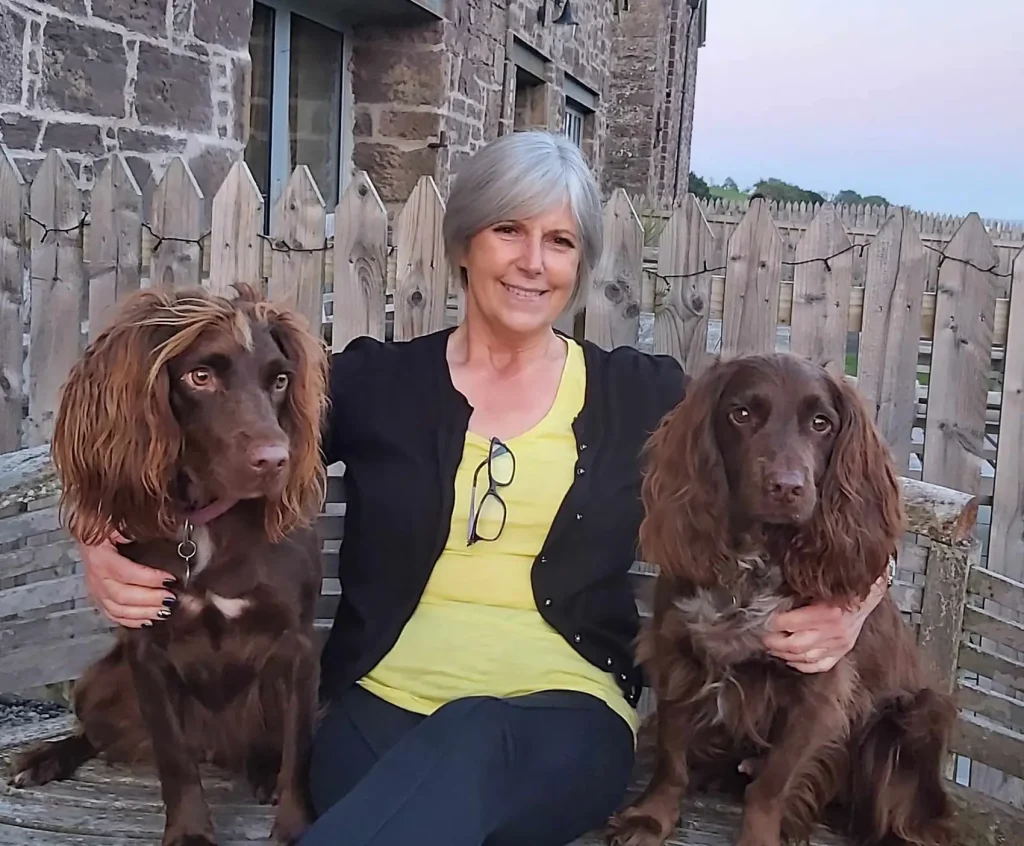 Photo of Trustee and Rehoming Manager with her two brown spaniels