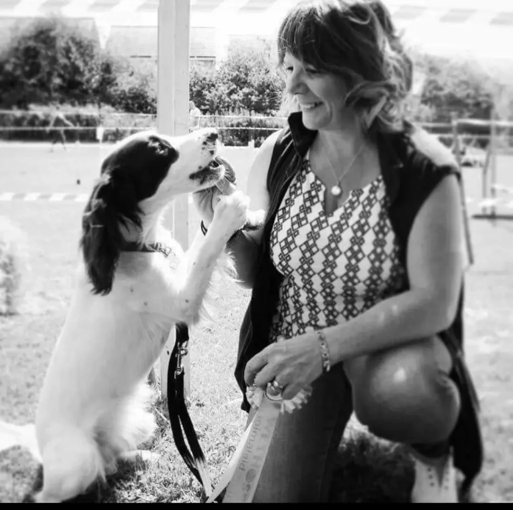 A photo of Lisa, the founder of UK Spaniel Rescue with her spaniel sitting outdoors